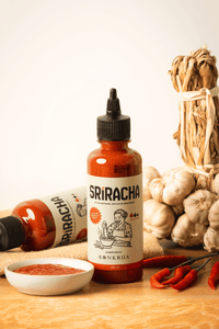 Thumbnail for KONKRUA Thai Sriracha Sauce, 250-ml-Flasche, umgeben von frischem Knoblauch, roten Chilis und einer Schale Sriracha